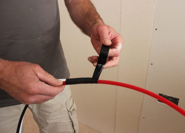 Super Rod Cable Tongue being used on site - person is seen attaching cables to the cable tongue tool
