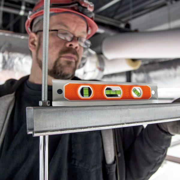 KLEIN TOOLS Torpedo Level being used to check the level of a surface by a worker on site
